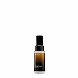 Amber glass bottle with black pump dispenser containing facial oil serum on a white background.