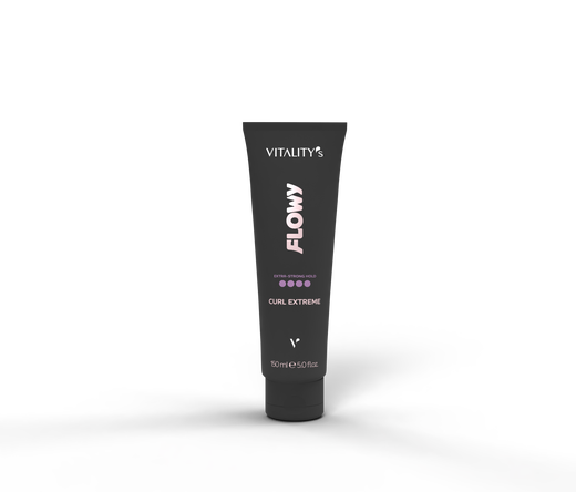 Black squeeze tube labeled "Vitality's Flowy Curl Extreme" standing upright on a dark textured surface with a soft shadow, a hair styling product