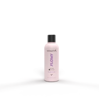 Pink bottle labeled 'Flowy' on a glossy reflective surface with a pale pink background behind it.
