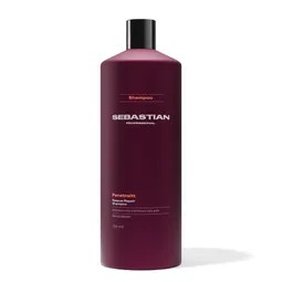 Tall maroon shampoo bottle with a black cap and Sebastian Professional branding, standing on a white surface.